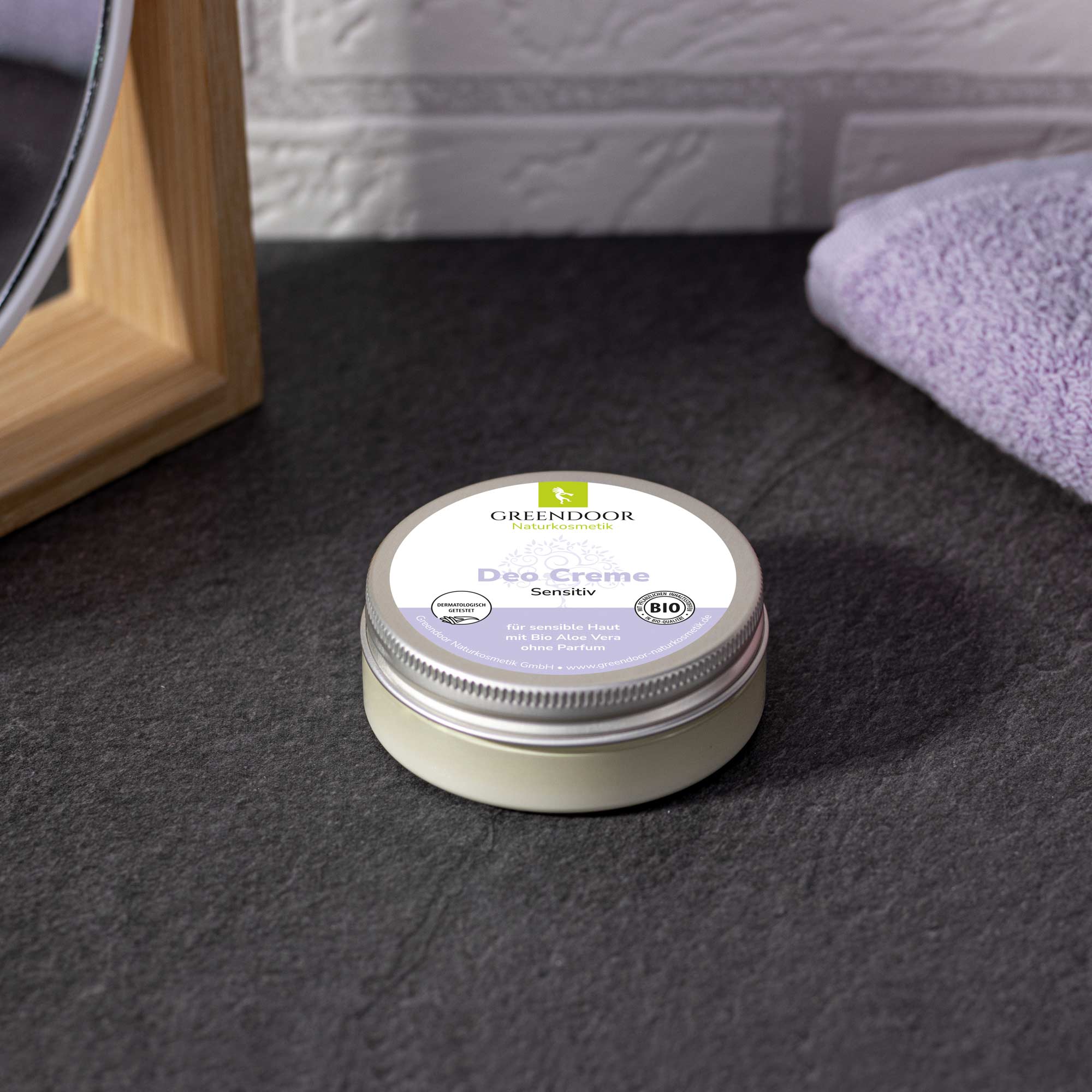 Greendoor Bio Deo Creme Sensitiv im Badezimmer auf grauem Untergrund
