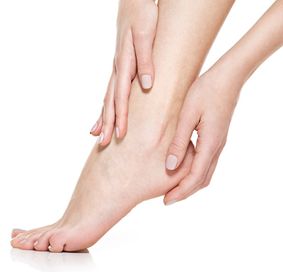 Nackter Fuß von zwei Händen umschmeichelt